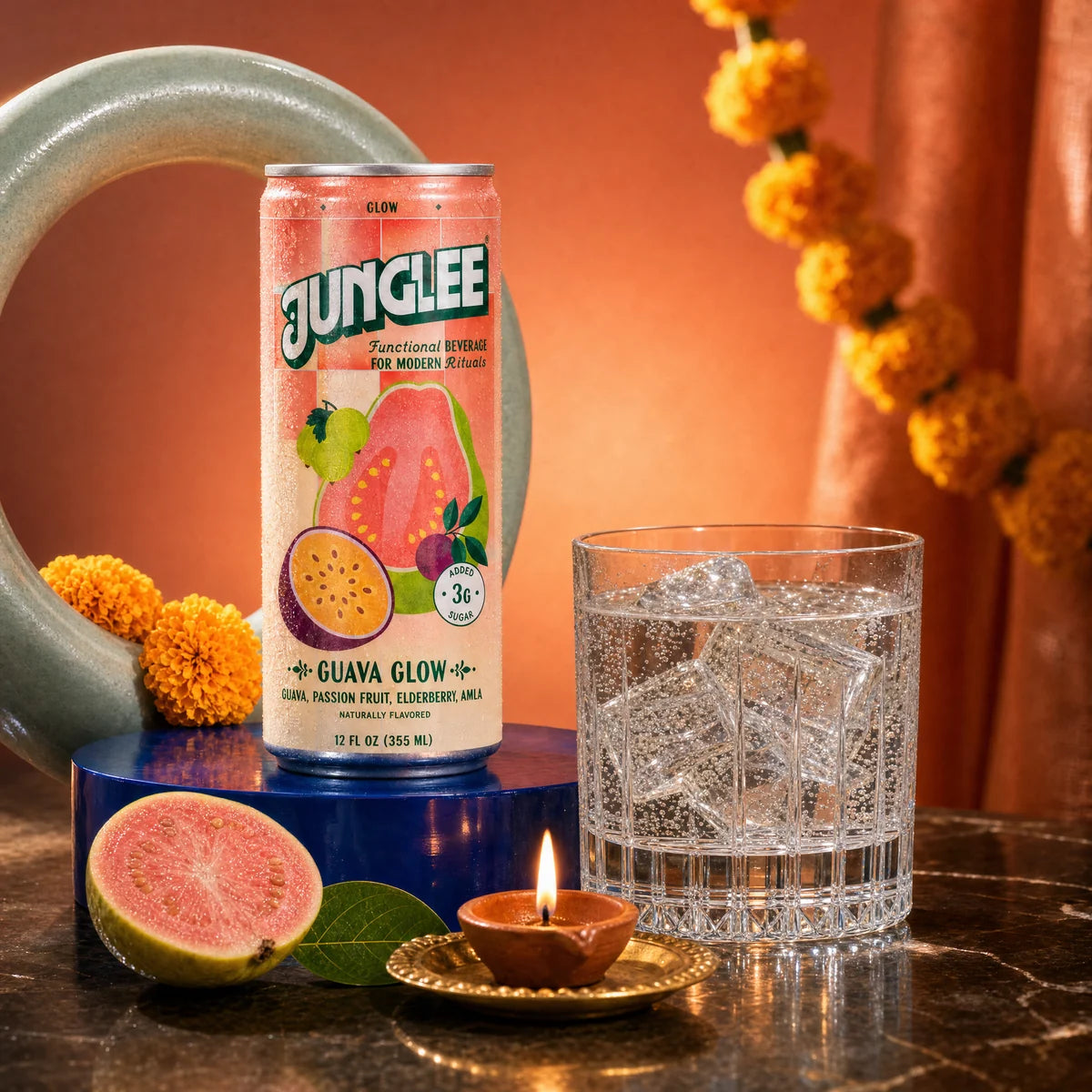 Guava Glow with a clear sparkling drink, celadon ceramic, marigolds and a clay diya