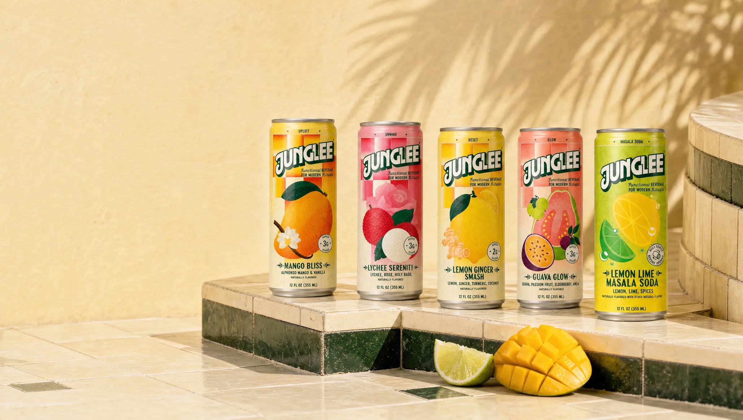 All five Junglee flavors lined up on ivory and deep green tiles against a sunlit butter-yellow wall: Mango Bliss, Lychee Serenity, Lemon Ginger Smash, Guava Glow, and Lemon Lime Masala Soda.